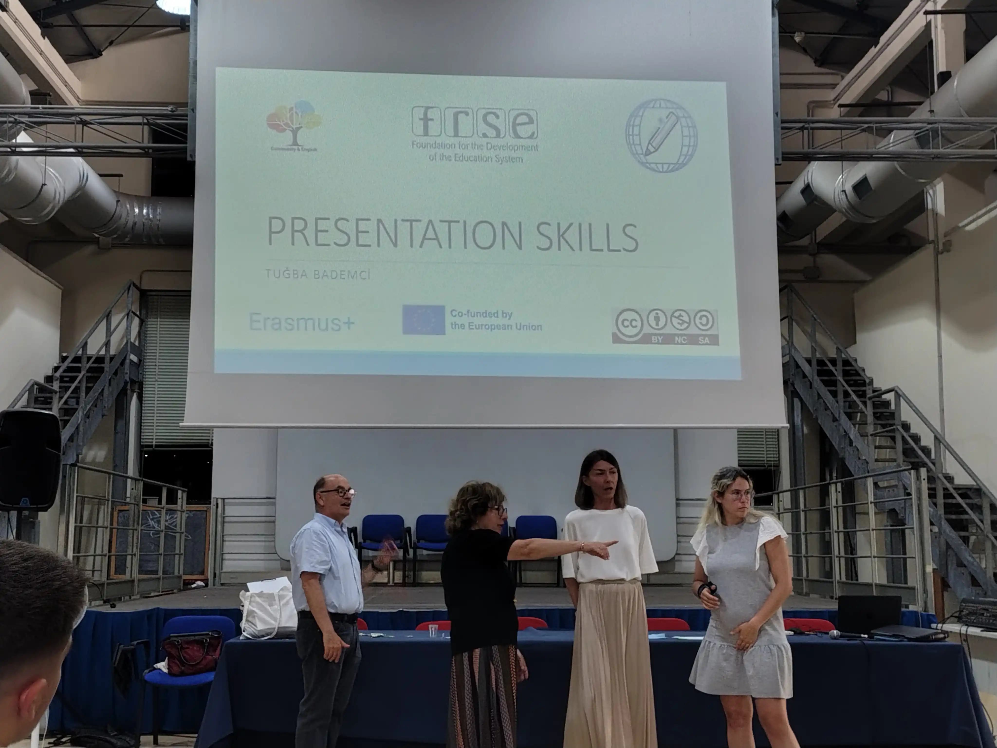 Participants introducing a Presentation Skills session in front of a projected slide during the Community & English Blended Mobility in Naples