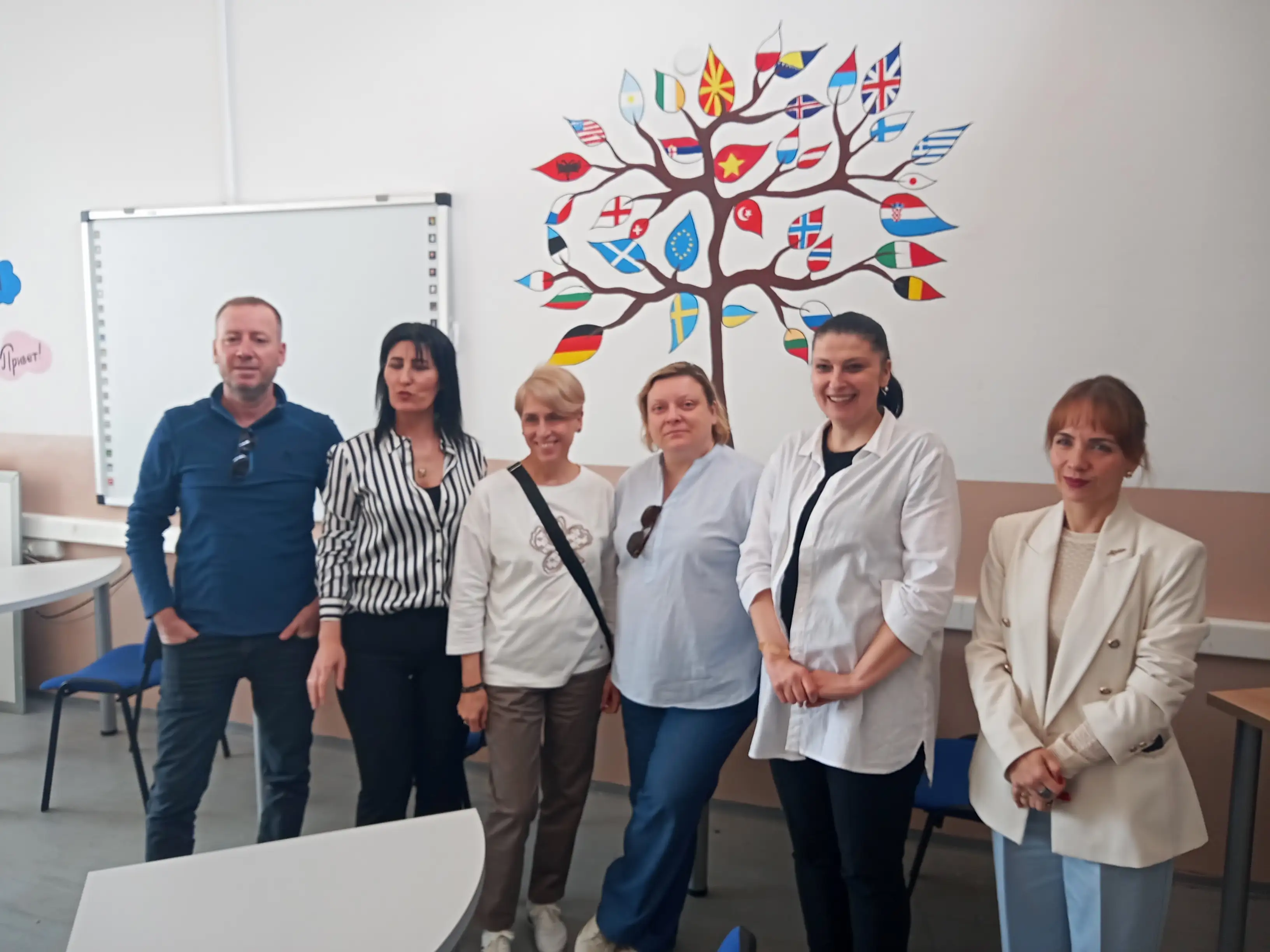 Community & English project representatives standing in front of a flag tree mural during the Kick-Off Meeting in Kočani