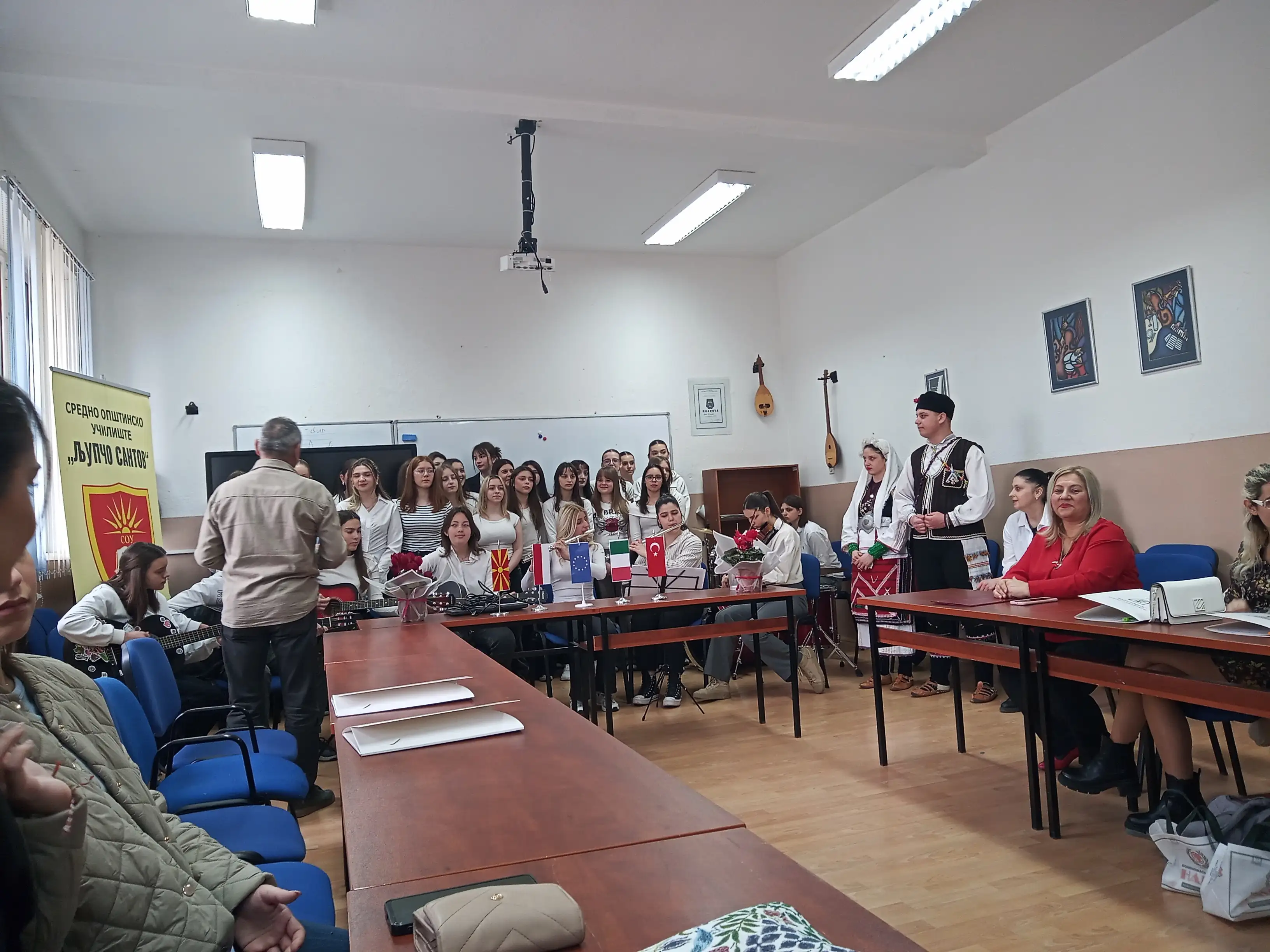 Students, some with guitars, gathered in front of the Community & English partners during the Kick-Off Meeting in Kočani