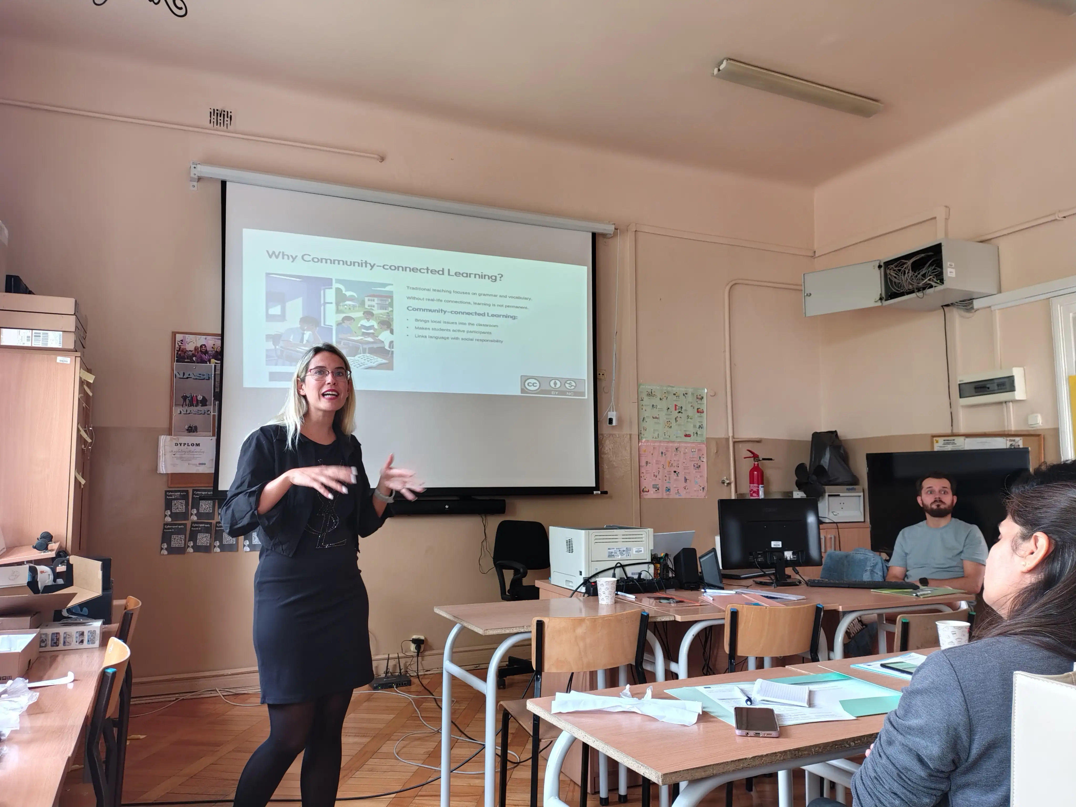 Presenter introducing Community-connected learning beside a projected slide during the first Community & English training event in Radom