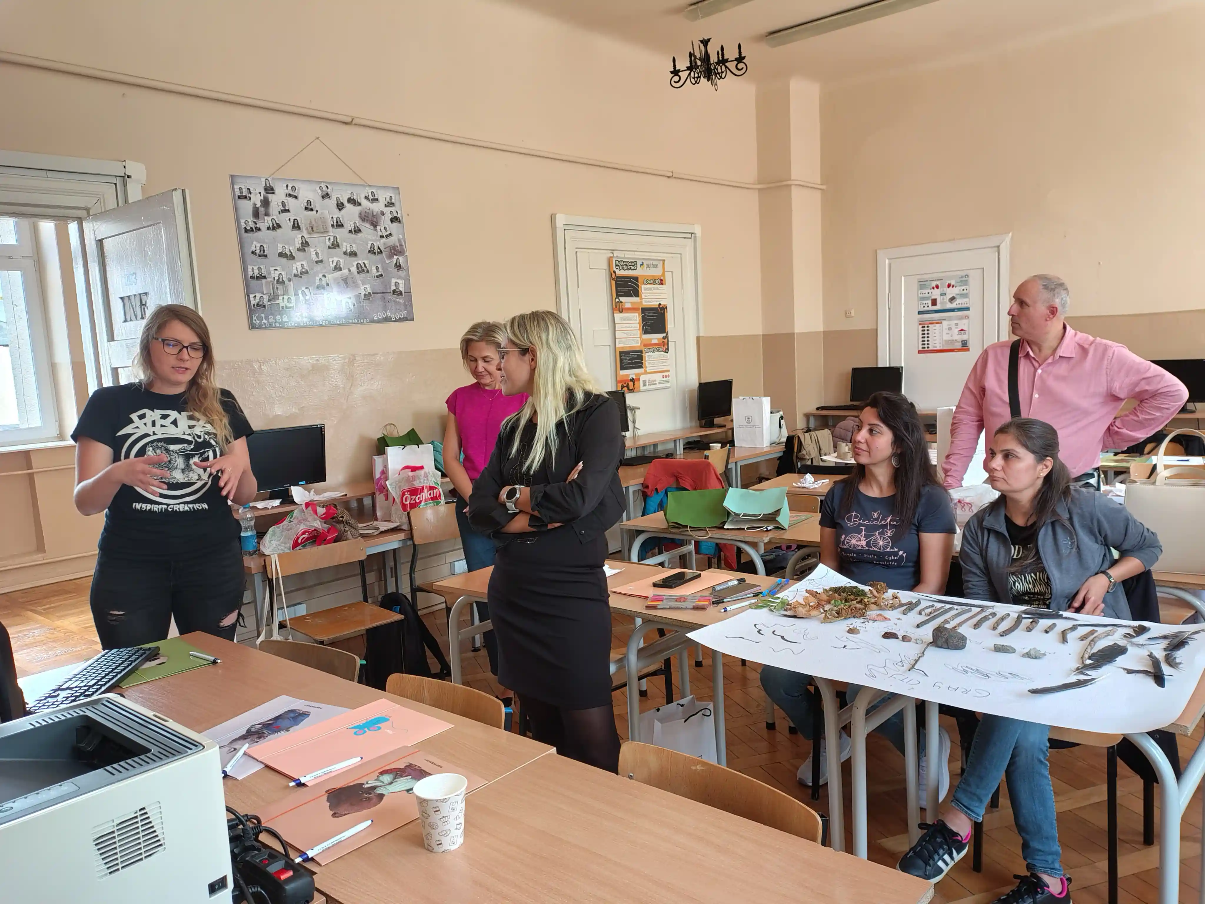 Teachers gathered around a table of collected natural objects during a group activity at the first Community & English training in Radom