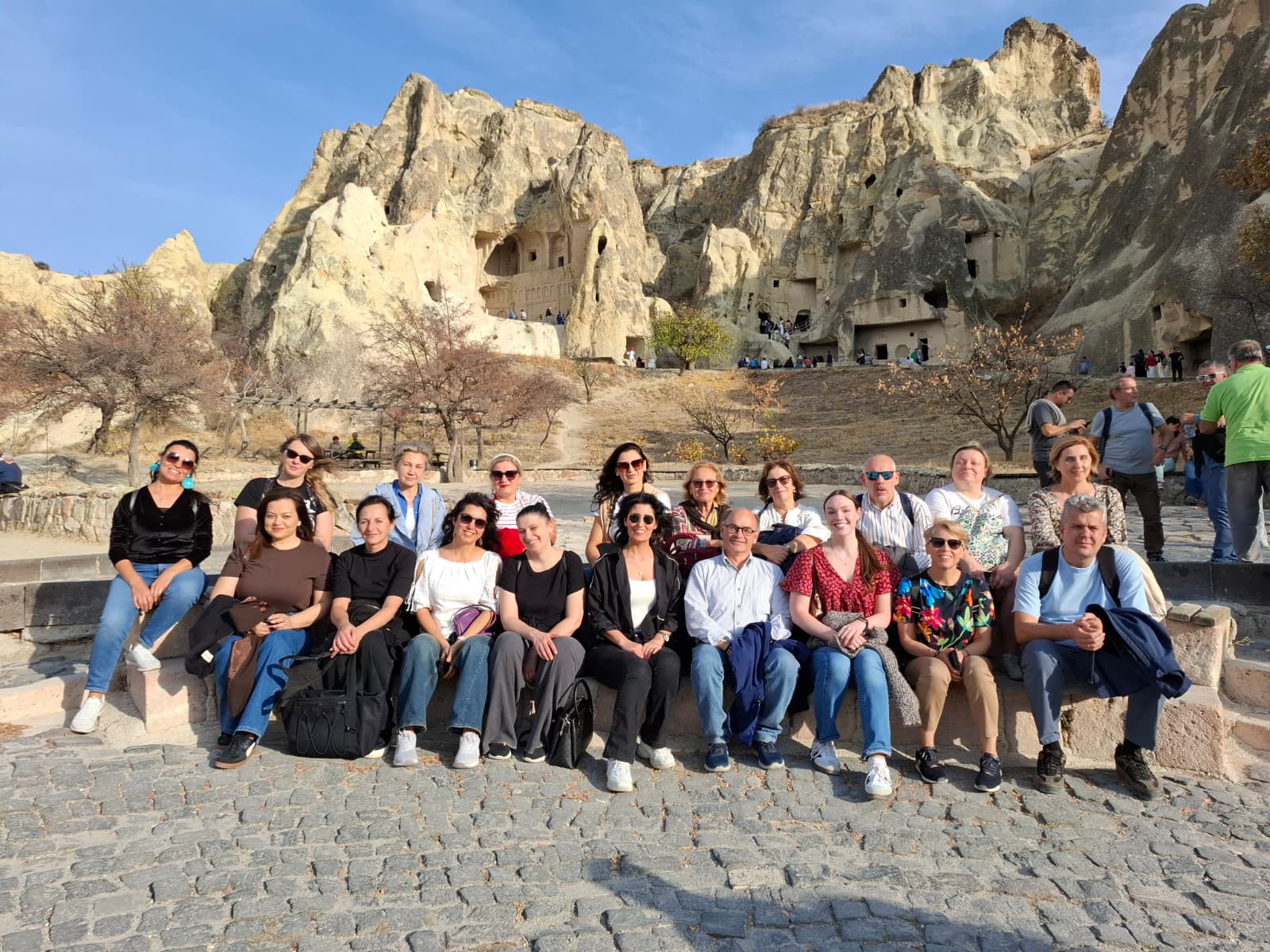 Community & English training participants in an outdoor group photo among rock formations in Türkiye